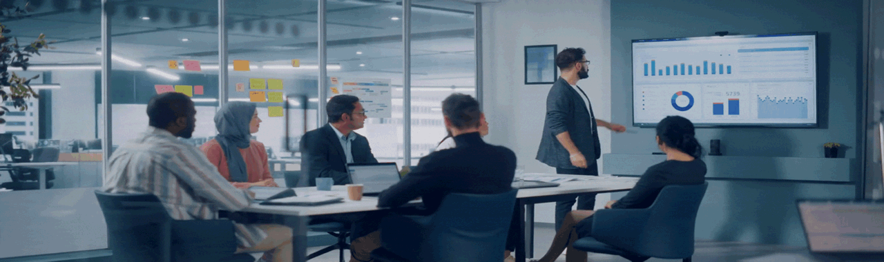 Conference room of people reviewing a report on a large screen on wall